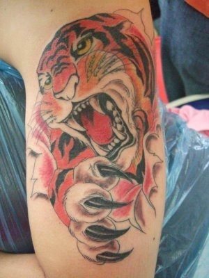 Tatuaje de un tigre fiero mostrando sus garras